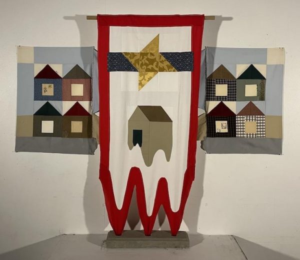 Fabric wall hanging made from house and star quilt blocks in red, white, blue and neutrals.