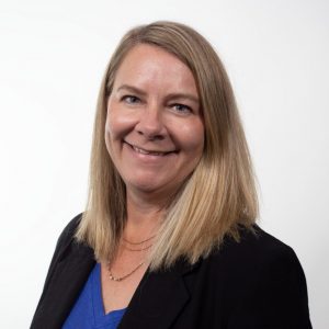 Head and shoulders photo of a woman in a blue shirt and a black jacket.