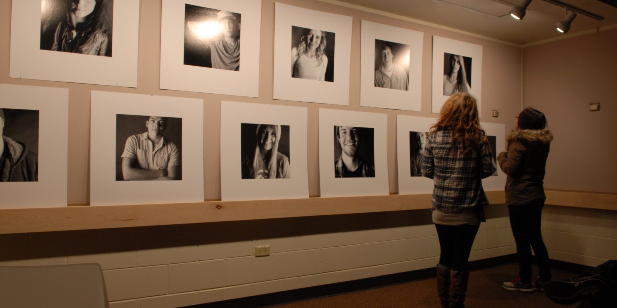 photo image making students admiring wall of photos